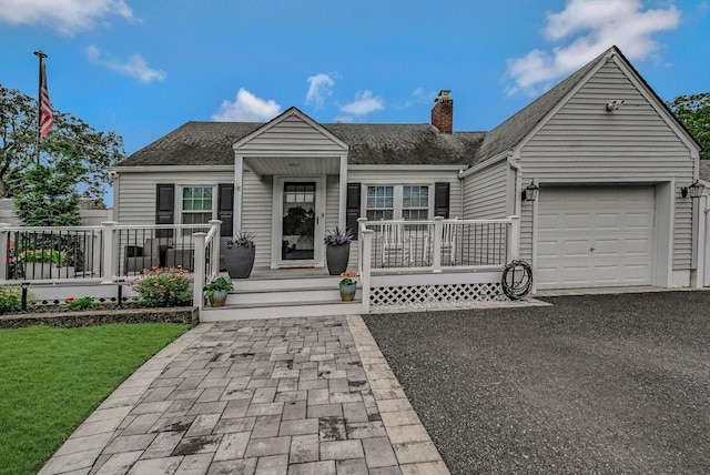 66 Eimer St, Patchogue, NY 11772 - view of front facade featuring an attached garage, a chimney, a shingled roof, and a front yard