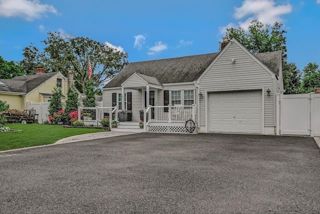 66 Eimer St, Patchogue, NY 11772 - cape cod house featuring a garage, covered porch, driveway, a shingled roof, and a gate