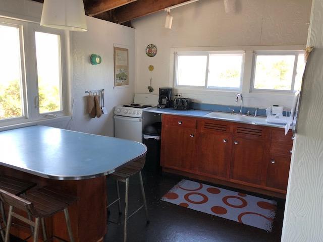 54 Lewis Walk, Cherry Grove, NY 11782 - kitchen featuring white range with electric stovetop, a breakfast bar area, light countertops, and beam ceiling