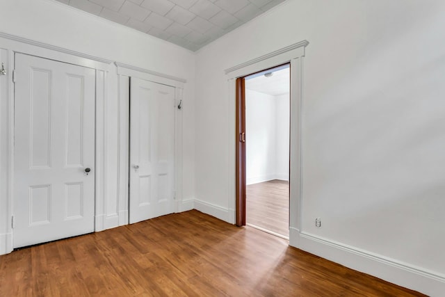 13-19 126th St, College Point, NY 11356 - unfurnished bedroom featuring wood finished floors, crown molding, and a closet