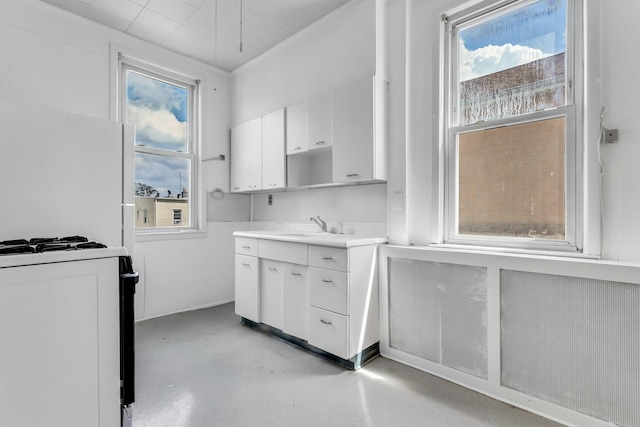13-19 126th St, College Point, NY 11356 - kitchen featuring white cabinets, gas range oven, concrete flooring, and light countertops