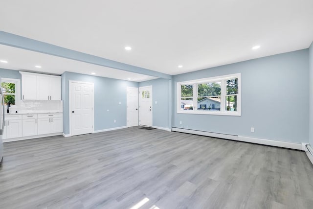 111A Wood Ave, Mastic, NY 11950 - unfurnished living room with a baseboard heating unit, light wood-style flooring, and recessed lighting