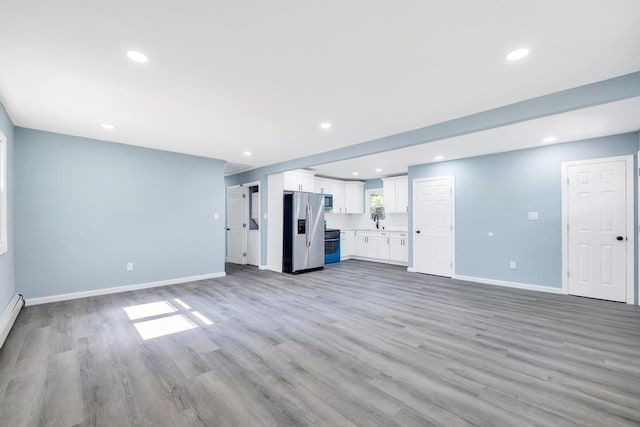 111A Wood Ave, Mastic, NY 11950 - unfurnished living room with light wood-style floors and recessed lighting