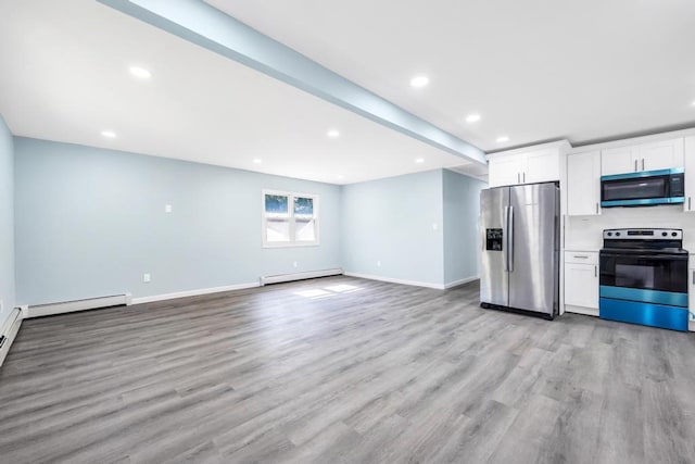 111A Wood Ave, Mastic, NY 11950 - kitchen featuring appliances with stainless steel finishes, baseboard heating, light wood-style floors, white cabinets, and recessed lighting