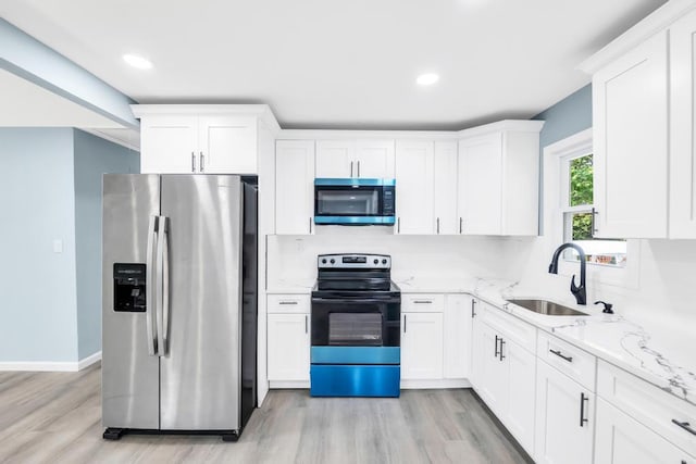 111A Wood Ave, Mastic, NY 11950 - kitchen with appliances with stainless steel finishes, white cabinetry, light wood-style floors, light stone countertops, and recessed lighting