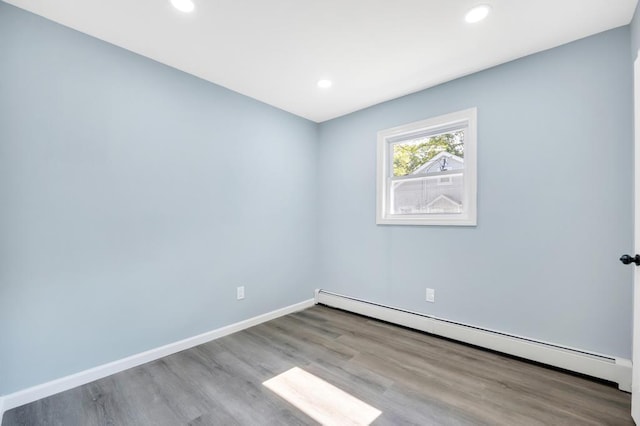111A Wood Ave, Mastic, NY 11950 - empty room featuring a baseboard heating unit, wood finished floors, and recessed lighting