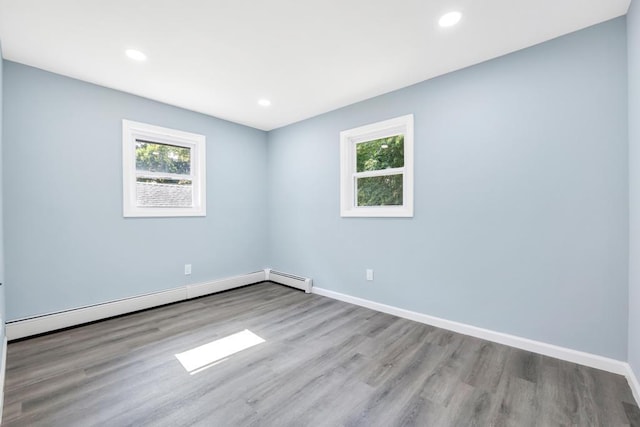 111A Wood Ave, Mastic, NY 11950 - unfurnished room with baseboard heating, healthy amount of natural light, wood finished floors, and recessed lighting