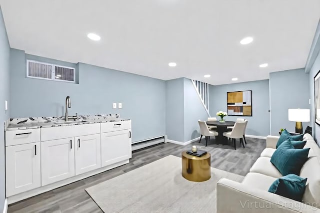 111A Wood Ave, Mastic, NY 11950 - living area with baseboard heating, wood finished floors, stairs, and recessed lighting