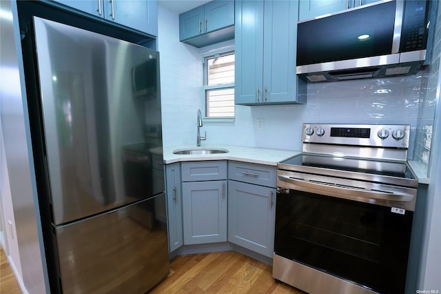 87-44 89th St, Woodhaven, NY 11421 - kitchen featuring appliances with stainless steel finishes, light wood-type flooring, gray cabinetry, tasteful backsplash, and light stone counters