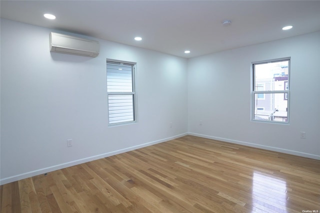 87-44 89th St, Woodhaven, NY 11421 - unfurnished room featuring a wall mounted AC, light wood-style flooring, and recessed lighting