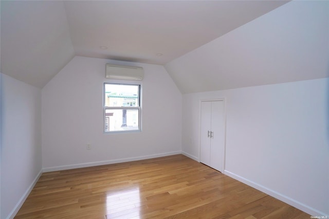 87-44 89th St, Woodhaven, NY 11421 - additional living space with a wall unit AC, light wood-type flooring, and vaulted ceiling