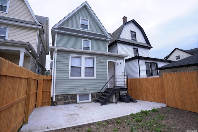 87-44 89th St, Woodhaven, NY 11421 - back of property featuring a fenced backyard, a chimney, and a patio area