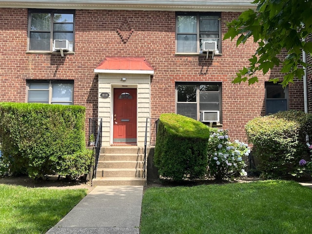 191-09 39th Ave Unit 164, Flushing, NY 11358 - view of front of house featuring brick siding, cooling unit, and a front lawn