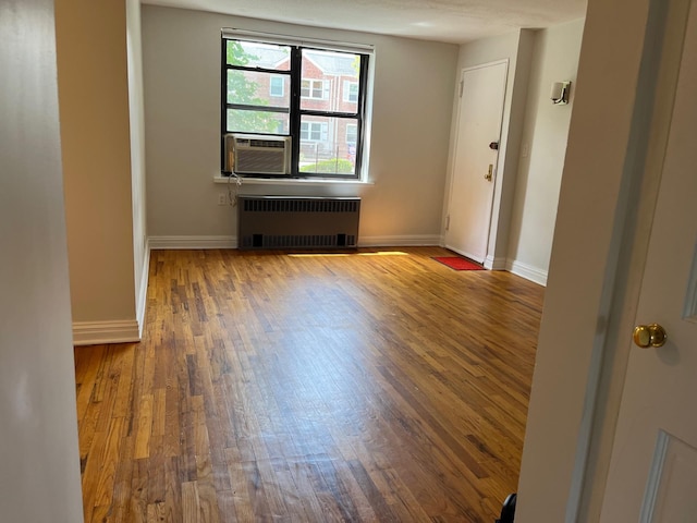 191-09 39th Ave Unit 164, Flushing, NY 11358 - spare room featuring radiator, wood finished floors, and cooling unit