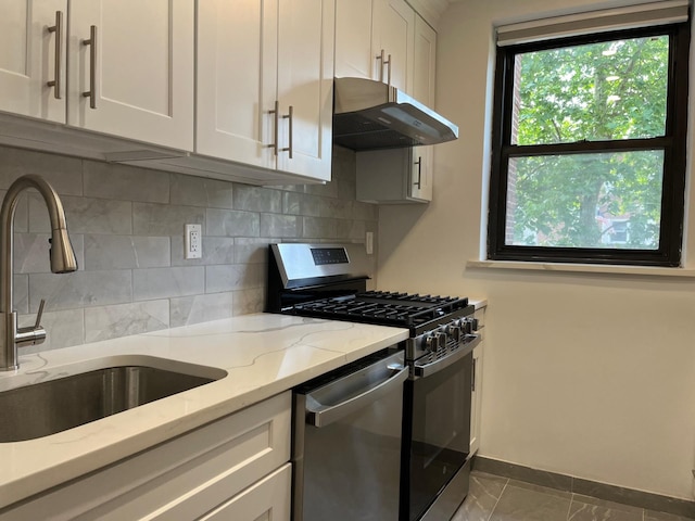 191-09 39th Ave Unit 164, Flushing, NY 11358 - kitchen featuring appliances with stainless steel finishes, under cabinet range hood, tasteful backsplash, white cabinets, and light stone countertops