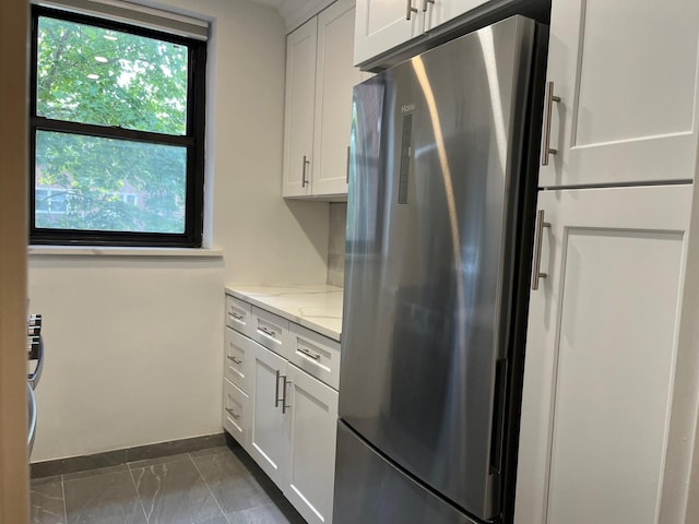 191-09 39th Ave Unit 164, Flushing, NY 11358 - kitchen featuring stainless steel fridge, light stone counters, white cabinetry, and dark marble finish flooring