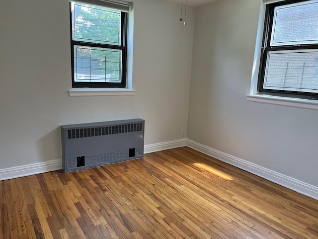 191-09 39th Ave Unit 164, Flushing, NY 11358 - unfurnished room with radiator and wood-type flooring