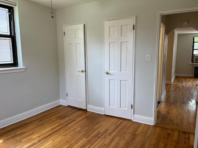 191-09 39th Ave Unit 164, Flushing, NY 11358 - unfurnished bedroom featuring light wood-style flooring and arched walkways
