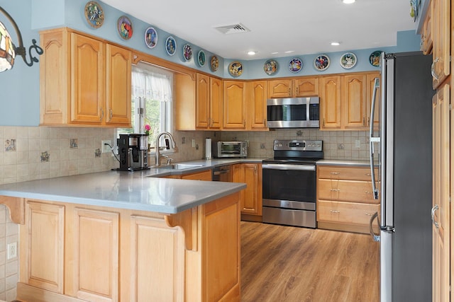 16 Mountain View Dr, Holmes, NY 12531 - kitchen featuring stainless steel appliances, a peninsula, light wood finished floors, decorative backsplash, and a breakfast bar area