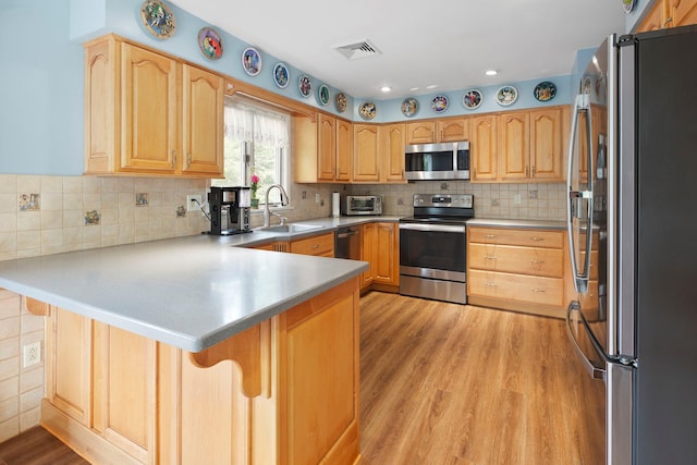 16 Mountain View Dr, Holmes, NY 12531 - kitchen with stainless steel appliances, a peninsula, light wood-style floors, a breakfast bar, and light brown cabinetry