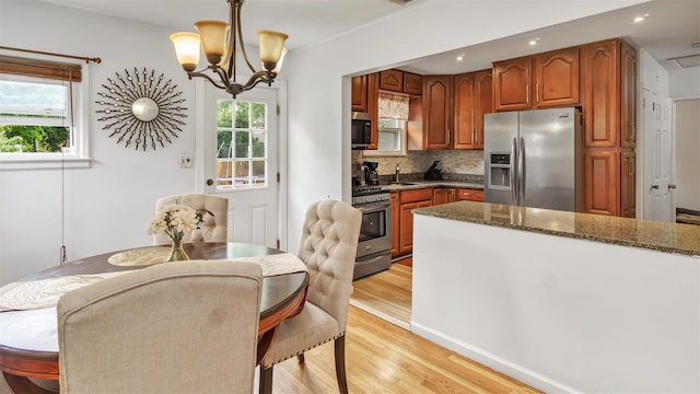 62 Harold Ave, Hempstead, NY 11550 - kitchen with appliances with stainless steel finishes, light wood-style floors, a chandelier, decorative backsplash, and recessed lighting