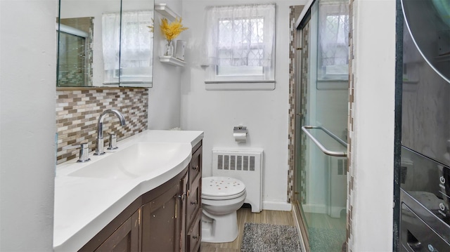 62 Harold Ave, Hempstead, NY 11550 - full bath featuring radiator heating unit, wood finished floors, vanity, a shower stall, and backsplash