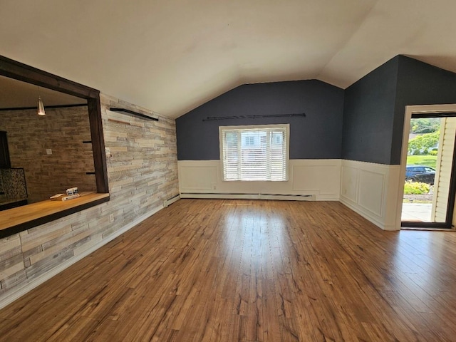 143 N Summit Ave, Patchogue, NY 11772 - unfurnished living room with baseboard heating, hardwood / wood-style flooring, a wainscoted wall, and vaulted ceiling