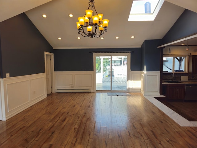143 N Summit Ave, Patchogue, NY 11772 - unfurnished living room featuring vaulted ceiling, a decorative wall, a baseboard radiator, a chandelier, and wood finished floors