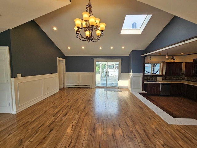 143 N Summit Ave, Patchogue, NY 11772 - unfurnished living room with lofted ceiling, wood finished floors, a skylight, a decorative wall, and a chandelier
