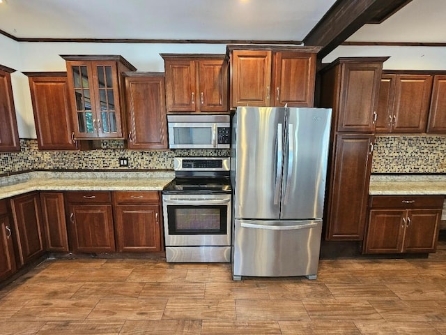 143 N Summit Ave, Patchogue, NY 11772 - kitchen with stainless steel appliances, decorative backsplash, crown molding, glass insert cabinets, and light stone counters
