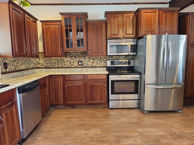 143 N Summit Ave, Patchogue, NY 11772 - kitchen with appliances with stainless steel finishes, light wood-style floors, glass insert cabinets, backsplash, and light stone counters