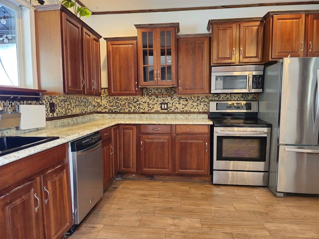 143 N Summit Ave, Patchogue, NY 11772 - kitchen featuring appliances with stainless steel finishes, light wood-style floors, decorative backsplash, and glass insert cabinets