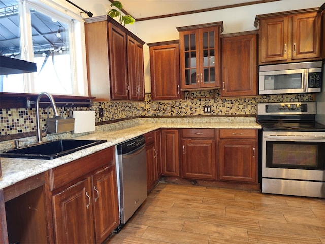 143 N Summit Ave, Patchogue, NY 11772 - kitchen featuring stainless steel appliances, tasteful backsplash, glass insert cabinets, light wood finished floors, and light stone counters