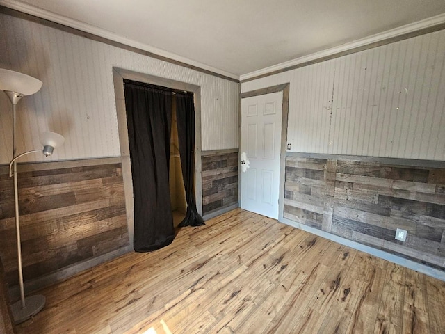 143 N Summit Ave, Patchogue, NY 11772 - spare room with ornamental molding, wooden walls, light wood-style flooring, and a wainscoted wall