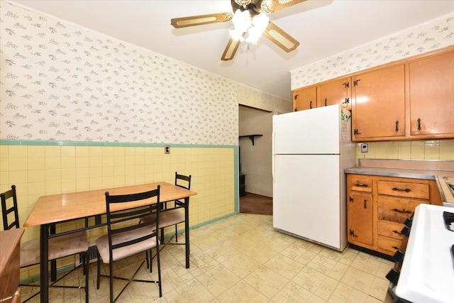 42 N Coleman Rd, Centereach, NY 11720 - kitchen with freestanding refrigerator, wallpapered walls, range, tile walls, and ceiling fan