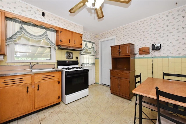 42 N Coleman Rd, Centereach, NY 11720 - kitchen featuring gas range, wallpapered walls, ceiling fan, light floors, and under cabinet range hood