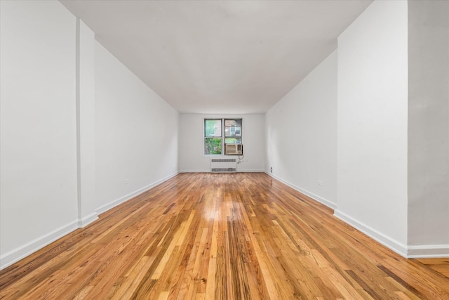67-30 Clyde St Unit 3L, Forest Hills, NY 11375 - spare room featuring light wood finished floors, cooling unit, and radiator heating unit