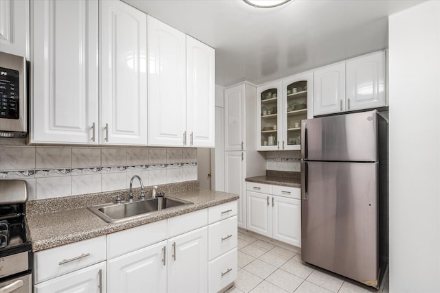 67-30 Clyde St Unit 3L, Forest Hills, NY 11375 - kitchen with stainless steel appliances, backsplash, glass insert cabinets, light tile patterned floors, and white cabinets