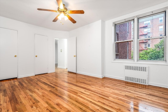67-30 Clyde St Unit 3L, Forest Hills, NY 11375 - unfurnished bedroom featuring radiator heating unit, light wood-style flooring, a ceiling fan, and multiple closets
