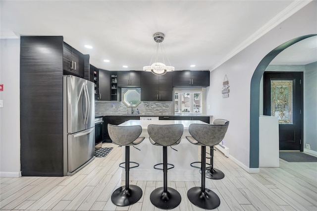 45 Potter Ln, Levittown, NY 11756 - kitchen with freestanding refrigerator, arched walkways, a breakfast bar, wood finish floors, and crown molding