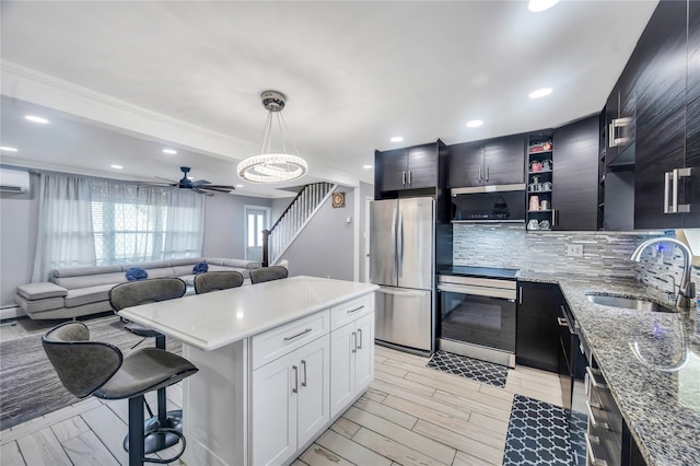 45 Potter Ln, Levittown, NY 11756 - kitchen featuring appliances with stainless steel finishes, a breakfast bar area, tasteful backsplash, open floor plan, and a ceiling fan