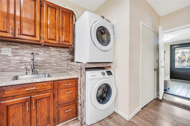 45 Potter Ln, Levittown, NY 11756 - laundry area featuring estacked washer and dryer, cabinet space, and light wood-style flooring
