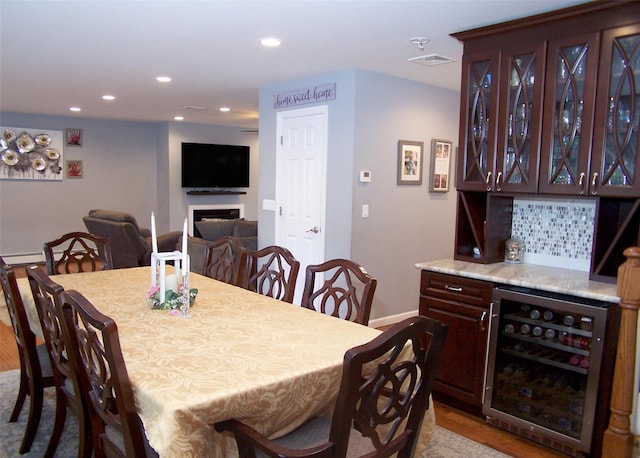 8 Mannes St, Ronkonkoma, NY 11779 - dining area featuring beverage cooler, a dry bar, recessed lighting, a fireplace, and wood finished floors