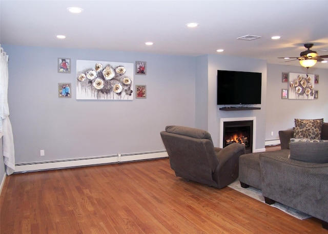 8 Mannes St, Ronkonkoma, NY 11779 - living room featuring baseboard heating, a lit fireplace, wood finished floors, recessed lighting, and ceiling fan
