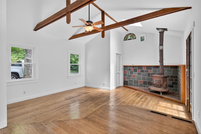 123 Newport Bridge Rd, Warwick, NY 10990 - unfurnished living room featuring a wood stove, beam ceiling, high vaulted ceiling, wood finished floors, and ceiling fan