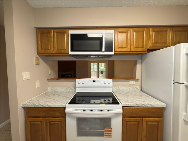 59 Meadowlark Ln, Woodridge, NY 12789 - kitchen featuring white appliances, brown cabinetry, and tile patterned flooring