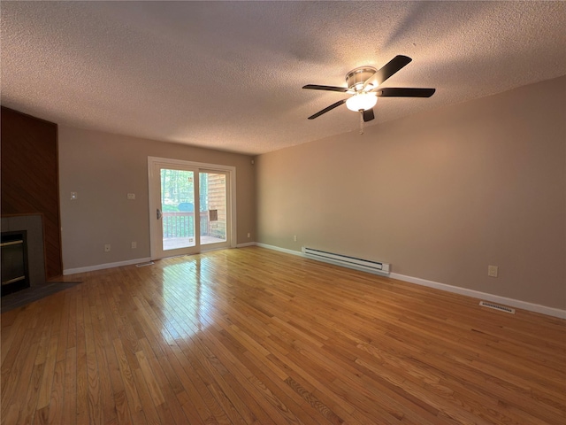 59 Meadowlark Ln, Woodridge, NY 12789 - unfurnished living room with a baseboard heating unit, a textured ceiling, light wood-style flooring, ceiling fan, and a fireplace with flush hearth