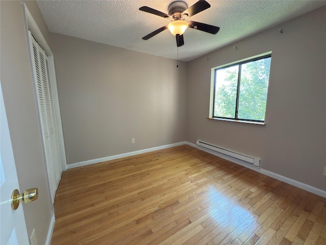 59 Meadowlark Ln, Woodridge, NY 12789 - unfurnished bedroom featuring a baseboard radiator, light wood-style floors, a textured ceiling, a closet, and a ceiling fan