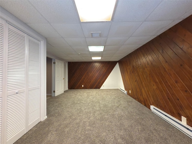 59 Meadowlark Ln, Woodridge, NY 12789 - finished basement with a baseboard radiator, wooden walls, dark colored carpet, and a drop ceiling