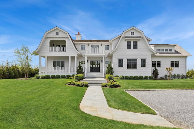 1 Fiske Ave, Westhampton Beach, NY 11978 - shingle-style home with a balcony, a gambrel roof, a front lawn, and roof with shingles